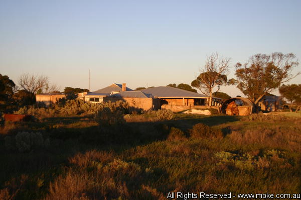 A picture of Koonalda Homestead at sunrise with shadows creeping across the scrub