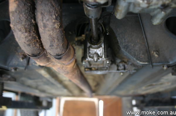 A picture of a twin pipe exhaust passing near the remote change box on a Moke.