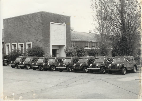 Picture of six army mokes parked outside a leyland factory building