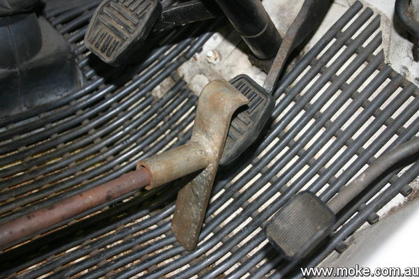 An image of a piece metal jammed on the brake pedal and the drivers seat.